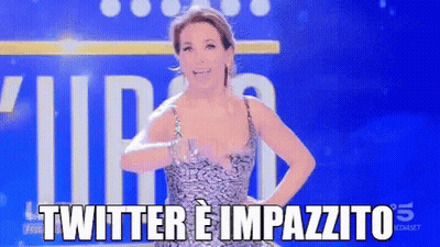 A Woman In A Dress Is Standing In Front Of A Blue Background That Says Twitter E Impazzito GIF