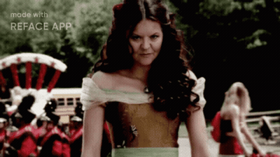 A Woman In A Dress Is Standing In Front Of A Crowd And The Words Made With Reface App Are On The Bottom Of The Screen GIF