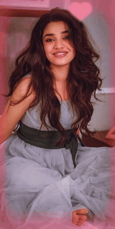 A Woman In A Dress With A Green Belt Around Her Waist Smiles For The Camera GIF