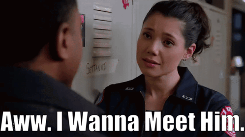 A Woman In A Firefighter Uniform Says " Aww I Wanna Meet Him " To A Man GIF