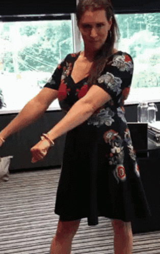 A Woman In A Floral Dress Is Dancing GIF