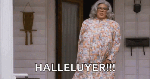 A Woman In A Floral Dress Is Standing In Front Of A Door And Says Halleluyer . GIF