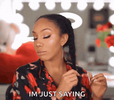 A Woman In A Floral Shirt Is Holding Her Hair And Saying Im Just Saying GIF