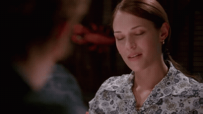 A Woman In A Floral Shirt Is Looking At Another Woman GIF