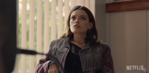 A Woman In A Fringed Jacket Is Sitting In Front Of A Window With A Netflix Logo On The Bottom GIF