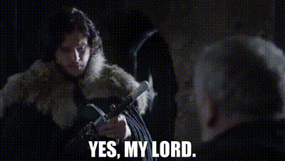 A Woman In A Fur Coat Is Holding A Sword And Talking To A Man In A Dark Room . GIF