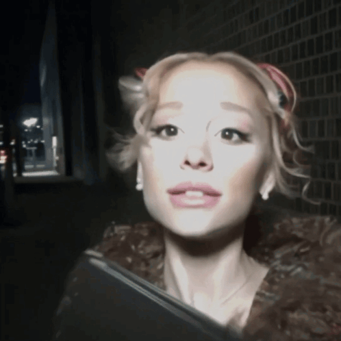 A Woman In A Fur Coat Is Looking At The Camera With A Serious Look On Her Face GIF