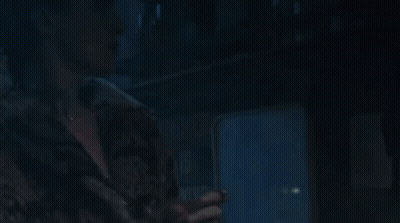 A Woman In A Fur Coat Is Looking Up At Something GIF