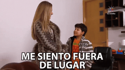 A Woman In A Fur Coat Is Talking To A Young Boy Who Is Wearing A Shirt That Says ' Tommy Hilfiger ' GIF