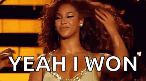 A Woman In A Gold Dress Is Holding Her Hair And Smiling While Saying Yeah I Won . GIF
