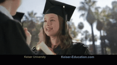 A Woman In A Graduation Cap And Gown Is Smiling And Holding A Diploma GIF