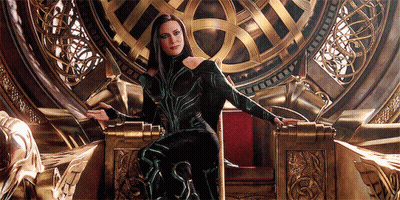 A Woman In A Green And Black Costume Is Sitting On A Gold Throne GIF