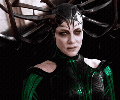 A Woman In A Green And Black Costume With A Helmet On Her Head GIF