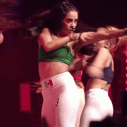 A Woman In A Green Crop Top And White Pants With The Number 3 On Them GIF