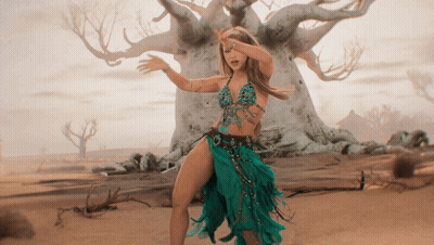 A Woman In A Green Dress Dancing In Front Of A Tree GIF