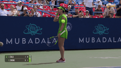 A Woman In A Green Dress Holds A Tennis Racquet In Front Of A Mubadala Sign GIF