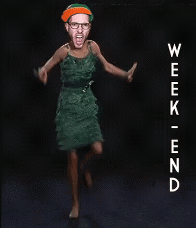 A Woman In A Green Dress Is Dancing In Front Of A Sign That Says Week End GIF