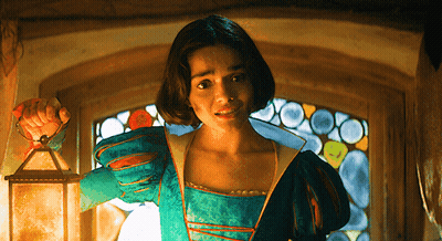 A Woman In A Green Dress Is Holding A Lantern GIF