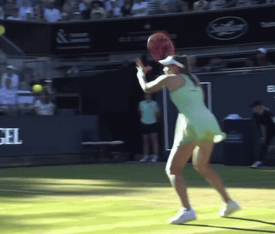A Woman In A Green Dress Is Holding A Tennis Racket On A Tennis Court GIF