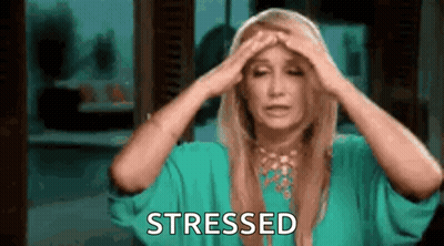 A Woman In A Green Dress Is Holding Her Head In Pain And Stressed . GIF