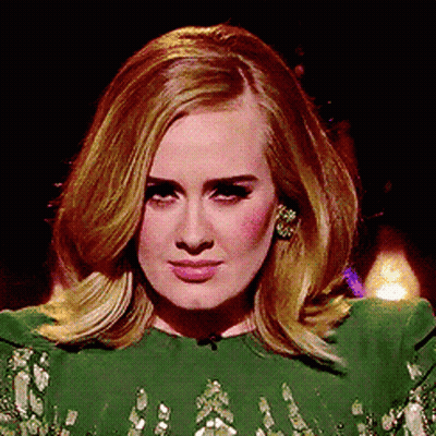 A Woman In A Green Dress Is Looking At The Camera GIF
