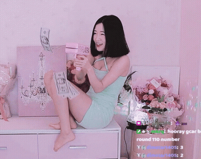A Woman In A Green Dress Is Sitting On A Dresser With A Round 110 Number On The Bottom Right GIF