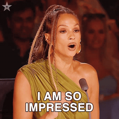 A Woman In A Green Dress Is Speaking Into A Microphone And Says " I Am So Impressed " GIF