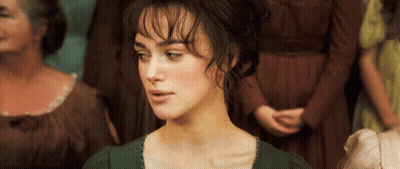 A Woman In A Green Dress Is Standing In Front Of A Crowd Of Women . GIF