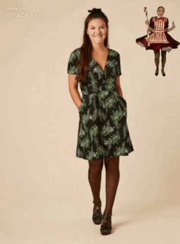 A Woman In A Green Dress Is Standing In Front Of A Picture Of A Girl In A Red Dress GIF