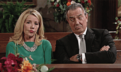 A Woman In A Green Dress Sits Next To A Man In A Suit GIF
