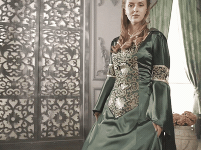 A Woman In A Green Dress With Gold Embroidery GIF