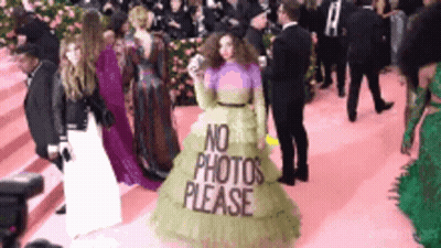 A Woman In A Green Dress With The Words No Photos Please On It GIF