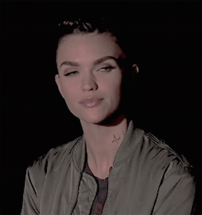 A Woman In A Green Jacket Has A Tattoo On Her Neck GIF