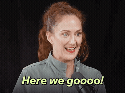 A Woman In A Green Jacket Is Smiling And Says Here We Goooo GIF