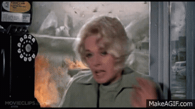 A Woman In A Green Jacket Is Talking On A Pay Phone GIF