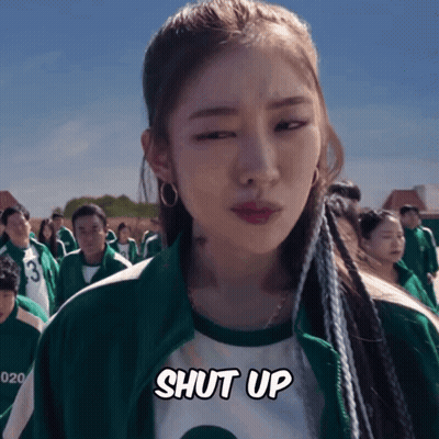A Woman In A Green Jacket Says Shut Up In Front Of A Crowd GIF