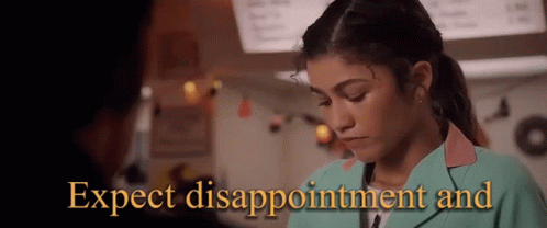 A Woman In A Green Jacket With The Words Expect Disappointment And Written On It GIF