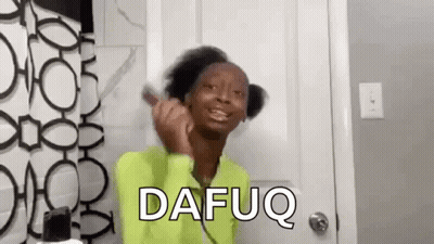 A Woman In A Green Shirt Is Brushing Her Hair In Front Of A Mirror . GIF