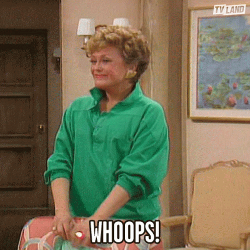 A Woman In A Green Shirt Is Standing In Front Of A Painting And Says Whoops . GIF