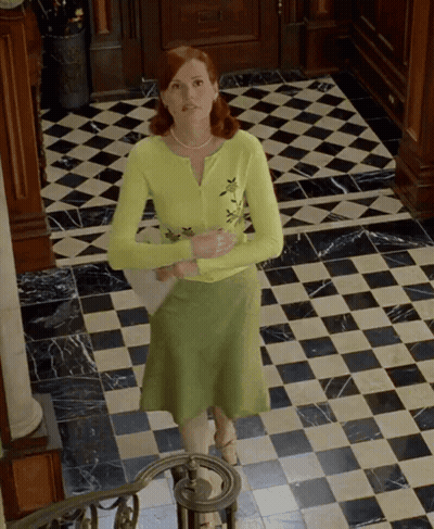A Woman In A Green Skirt Is Standing On A Checkered Tile Floor GIF