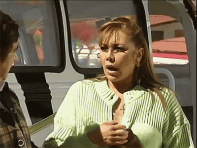 A Woman In A Green Sweater With A Cross On Her Chest GIF