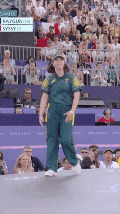 A Woman In A Green Uniform Stands In Front Of A Crowd At A Sports Event GIF