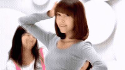A Woman In A Grey Shirt Is Standing Next To Another Woman In A Pink Shirt GIF