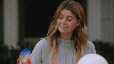 A Woman In A Grey Sweatshirt Is Looking Down GIF