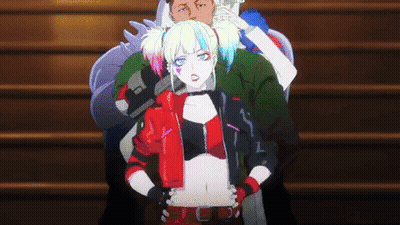A Woman In A Harley Quinn Costume Is Standing Next To A Man On A Set Of Stairs . GIF