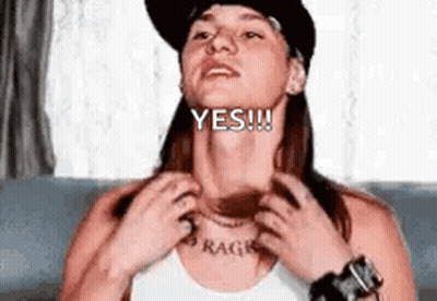 A Woman In A Hat Is Scratching Her Neck And Says Yes . GIF