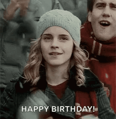 A Woman In A Hat Is Standing Next To A Man In A Scarf And A Man Is Singing Happy Birthday . GIF