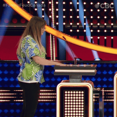 a woman in a hawaiian shirt is playing a game on a television show called family feud canada