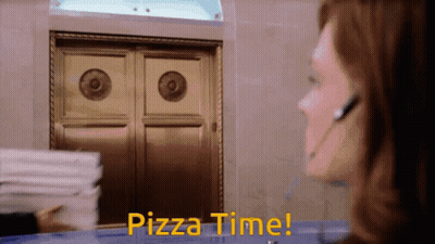 A Woman In A Headset Says Pizza Time In Front Of A Door GIF