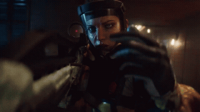 A Woman In A Helmet Is Holding A Rifle In Her Hand GIF